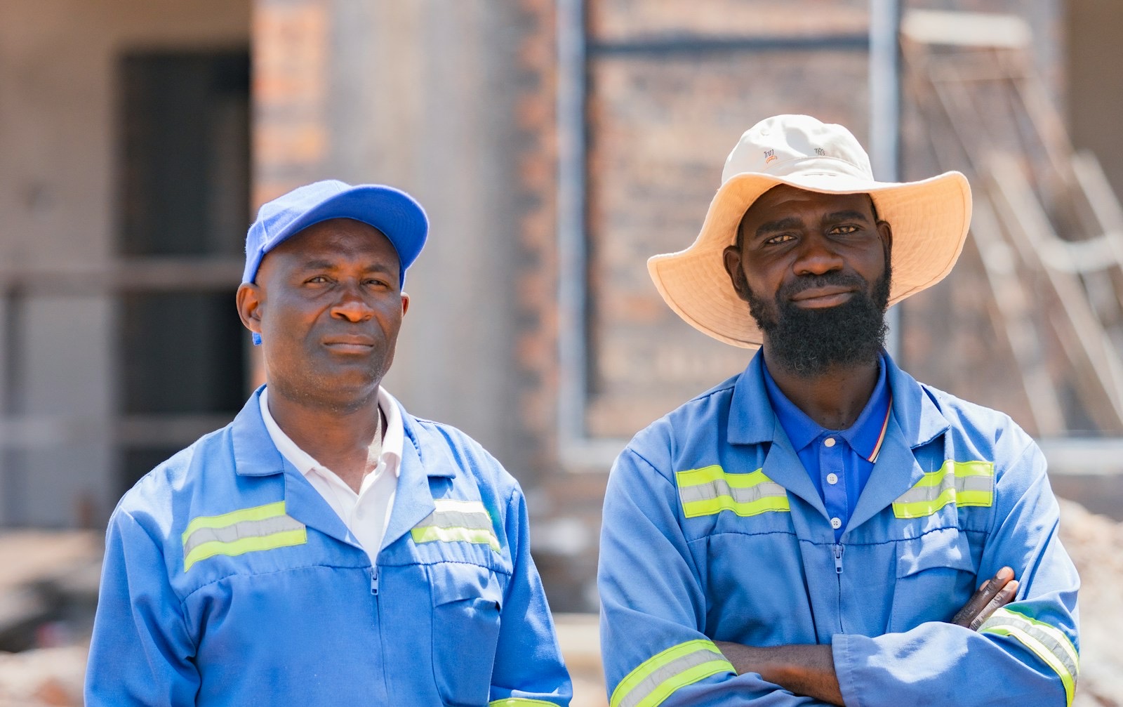 Two workers in safety coveralls at a construction site